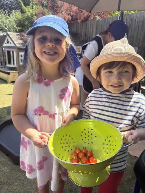Children holding freshly picked cherry tomatoes from the Montys garden