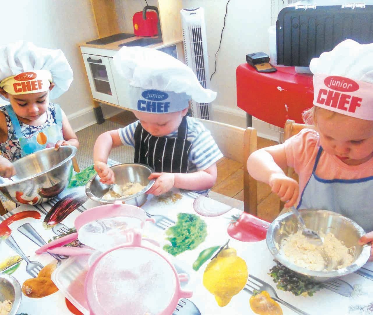 Children in junior chef hats cooking together at Montys